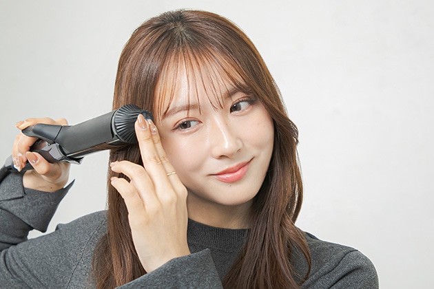 ②顔まわりの髪をリバース巻きにします。